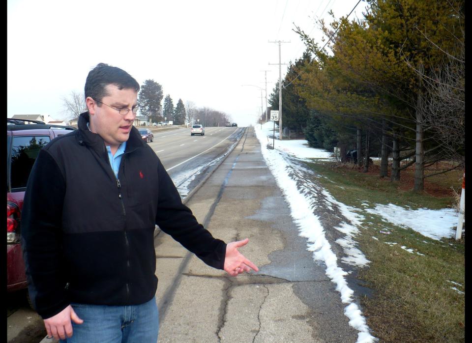 Mike Vega points to the area of sidewalk in Madison, Wis., Wednesday, Feb. 15, 2012, where he discovered a starving 15-year-old after she escaped from her abusive father and stepmother last week. The severely malnourished teenager had been forced to stay in an unfinished basement for years and an alarm would sound if she went upstairs, police records say. The teen told authorities she ate what she could find in the garbage and on the floor of her father and stepmother's Madison home. Sometimes she was made to eat her feces and drink her own urine, according to a police affidavit. (AP Photo/Todd Richmond)