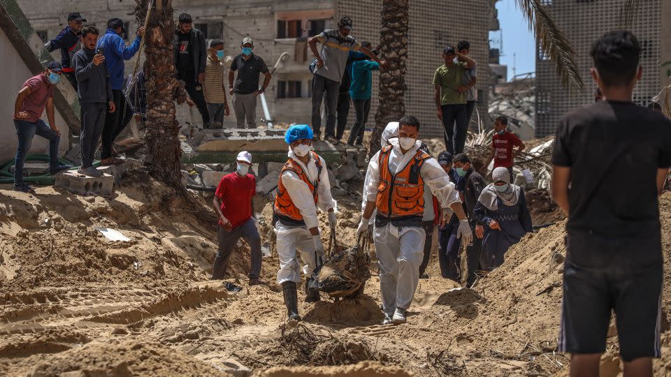 People and health workers unearth bodies found at Nasser Hospital in Khan Younis in the southern Gaza Strip on Tuesday. - AFP/Getty Images