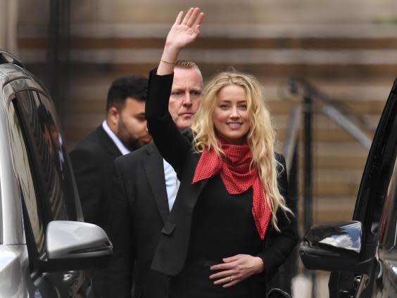 Amber Heard waves as she leaves the High Court in London (DANIEL LEAL-OLIVAS/AFP via Getty Images)