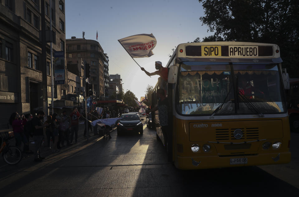 Un manifestante a favor de la reforma de la constitución chilena ondea una bandera en un evento de campaña en Santiago de Chile, el jueves 22 de octubre de 2020. (AP Foto/Esteban Félix)