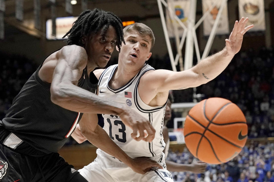 North Carolina State guard Dereon Seabron (1) and Duke forward Joey Baker (13) reach for the ball during the first half of an NCAA college basketball game in Durham, N.C., Saturday, Jan. 15, 2022. (AP Photo/Gerry Broome)