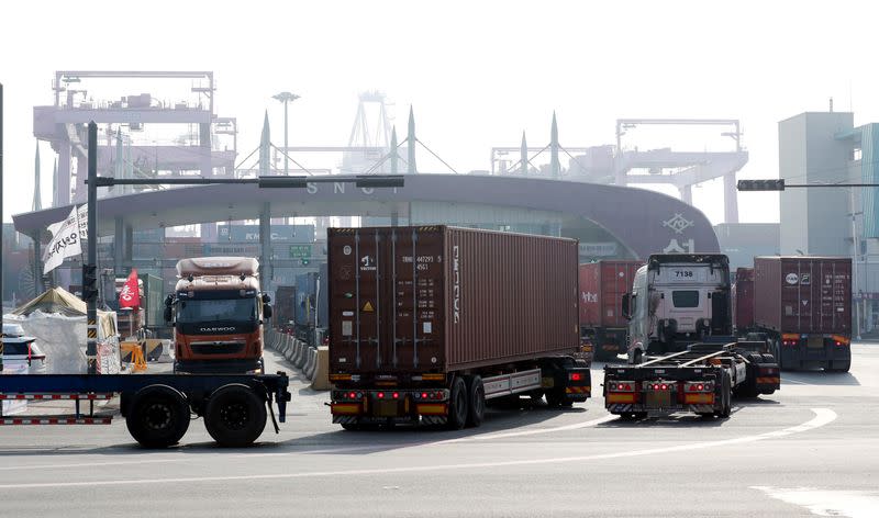 Trucks move into a port in Incheon, on the day truckers voted to end a nationwide strike