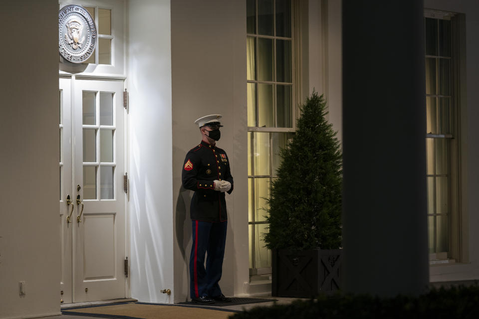 A Marine stands outside the entrance to the West Wing of the White House, signifying that President Donald Trump is in the Oval Office, Tuesday, Nov. 10, 2020, in Washington. (AP Photo/Evan Vucci)