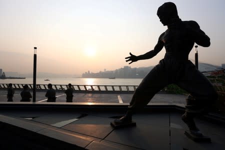 Police officers stand guard near the statue of Bruce Lee, ahead of a planned black balloon protest, at the Avenue of Stars in Tsim Sha Tsui, Hong Kong