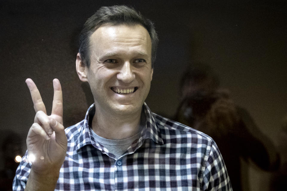 FILE - Russian opposition leader Alexei Navalny gestures as he stands behind a glass panel of a cage in the Babuskinsky District Court in Moscow, Russia, on Feb. 20, 2021. Navalny is due to hear the verdict Friday Aug. 4, 2023 in his latest trial on extremism charges. The prosecution has demanded a 20-year prison sentence, and the politician himself said he expects a lengthy prison term. (AP Photo/Alexander Zemlianichenko, File)