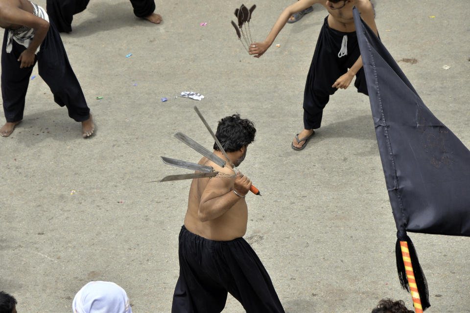 Shiite Muslims flagellate themselves with knifes on chains during a procession to mark Ashoura in Hyderabad, Pakistan, Saturday, July 29, 2023. Ashoura is the Shiite Muslim commemoration marking the death of Hussein, the grandson of the Prophet Muhammad, at the Battle of Karbala in present-day Iraq in the 7th century. (AP Photo/Pervez Masih)