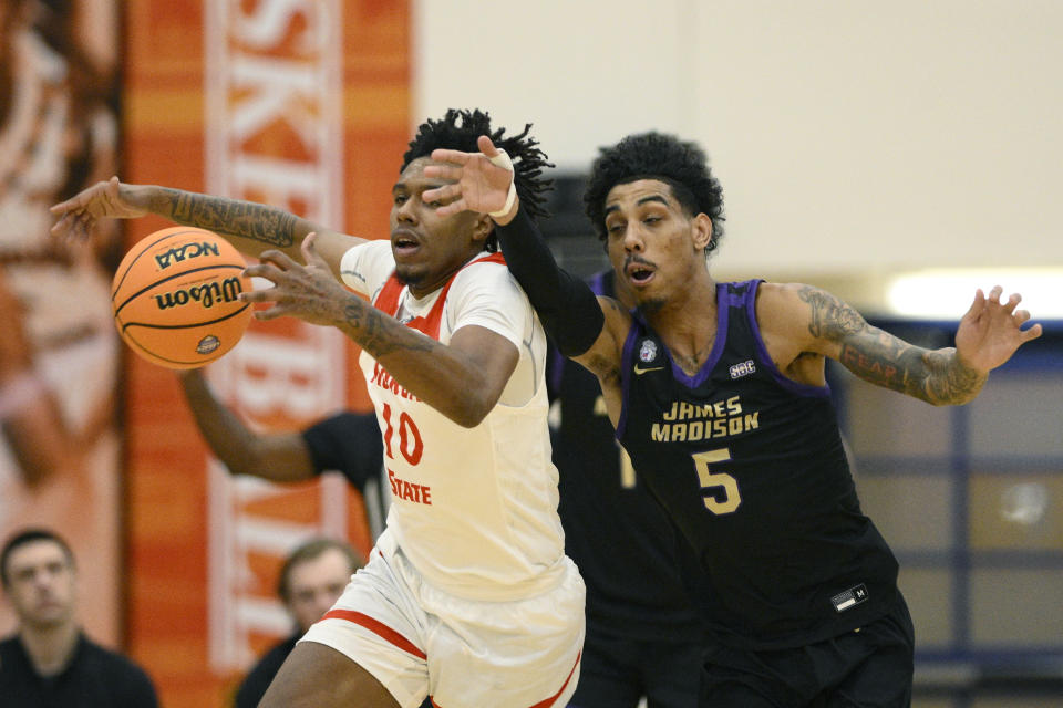 James Madison guard Terrence Edwards (5) and Morgan State forward Will Thomas (10) scramble for the ball during the first half of an NCAA college basketball game, Friday, Dec. 22, 2023, in Baltimore. (AP Photo/Nick Wass)