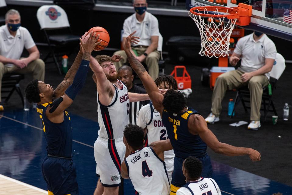 Gonzaga forward Drew Timme (2) rebounds the ball over West Virginia forward Gabe Osabuohien (3) and forward Derek Culver (1) in the second half at Bankers Life Fieldhouse.