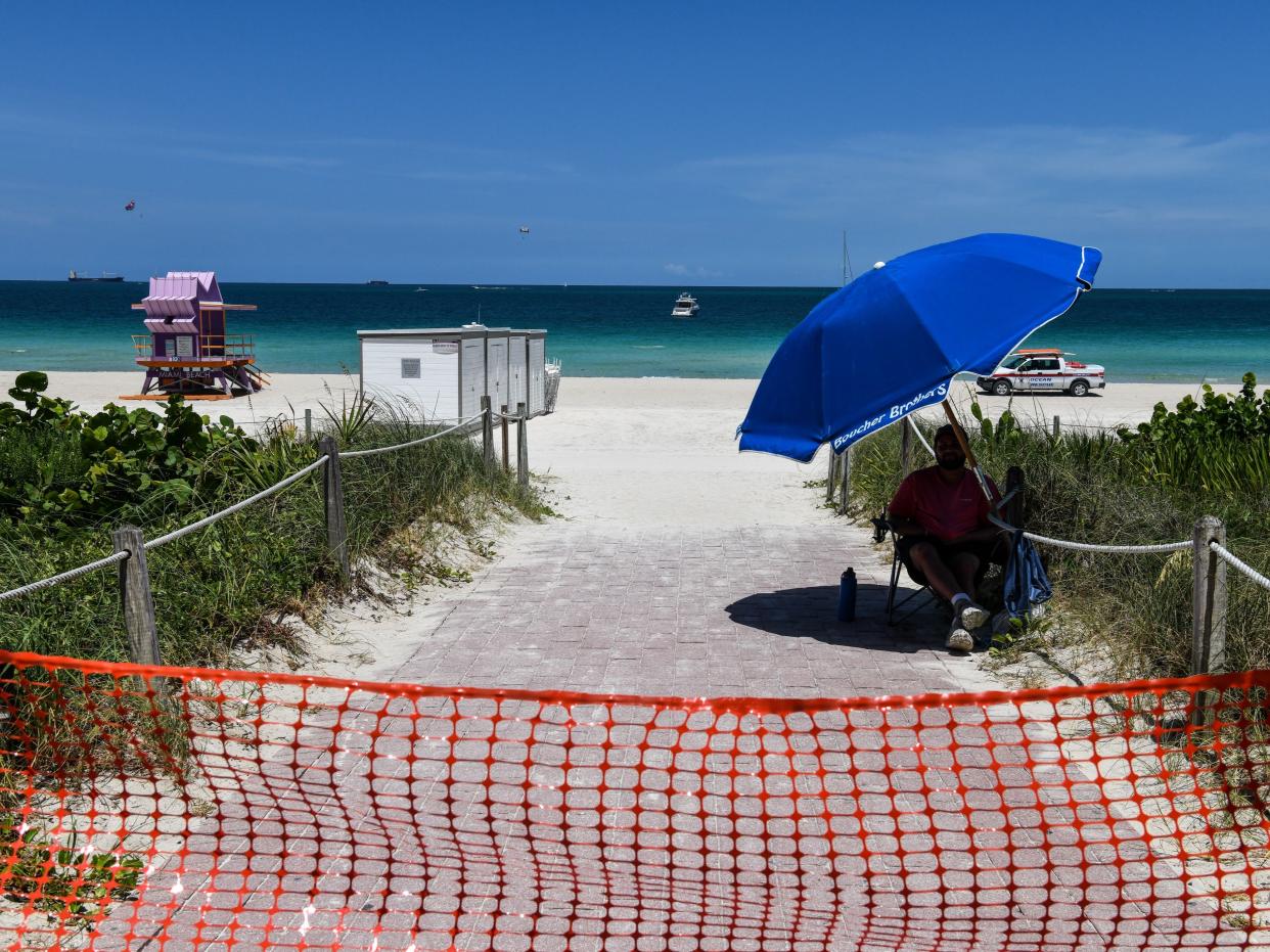 <p>An ocean rescue staff guards the closed beach ahead of the July 4th holiday weekend in Miami Beach, Miami, on 3 July 2020</p> ((AFP via Getty Images))