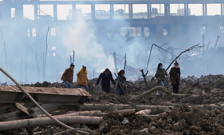 FILE PHOTO: Relatives look for a missing worker at the pesticide plant owned by Tianjiayi Chemical following an explosion, in Xiangshui county, Yancheng, Jiangsu province, China March 23, 2019. REUTERS/Aly Song