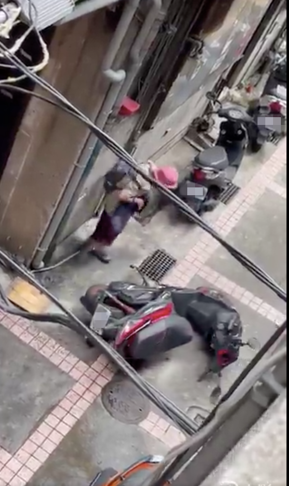 西門阿嬤在巷弄內一台台推倒陌生人機車。（圖片來源：翻攝自臉書社團「爆料公社」）