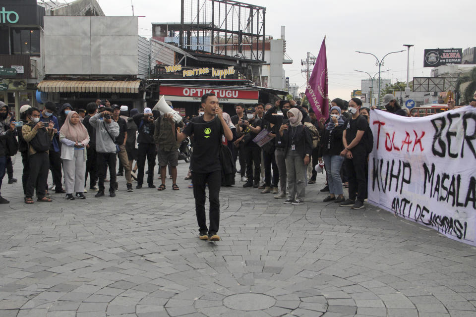 Activists stage a rally against Indonesia's new criminal law in Yogyakarta, Indonesia, Tuesday, Dec. 6, 2022. The country's parliament passed the long-awaited and controversial revision of its penal code Tuesday that criminalizes extramarital sex for citizens and visiting foreigners alike. Writings on the posters read "Reject the revised penal code" and "Revised criminal law shackles press freedom." (AP Photo/Slamet Riyadi)