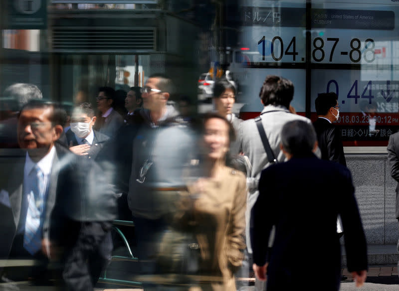 People walk past an electronic board showing exchange rate between Japanese Yen and U.S. Dollar outside a brokerage at a business district in Tokyo, Japan, March 23, 2018. REUTERS/Toru Hanai