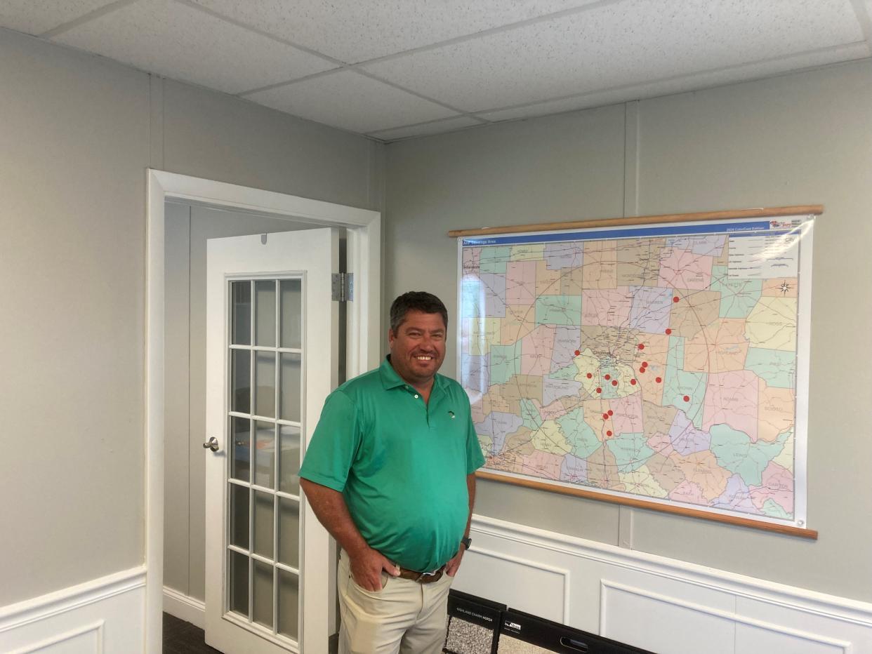 Brent Walker, general manager at America's Home Place, stands next to a map of the on-your-lot projects the homebuilder has under construction in the Cincinnati area. The company recently opened a new building center next to Interstate-75 in Erlanger, where its model homes can be seen from the freeway.