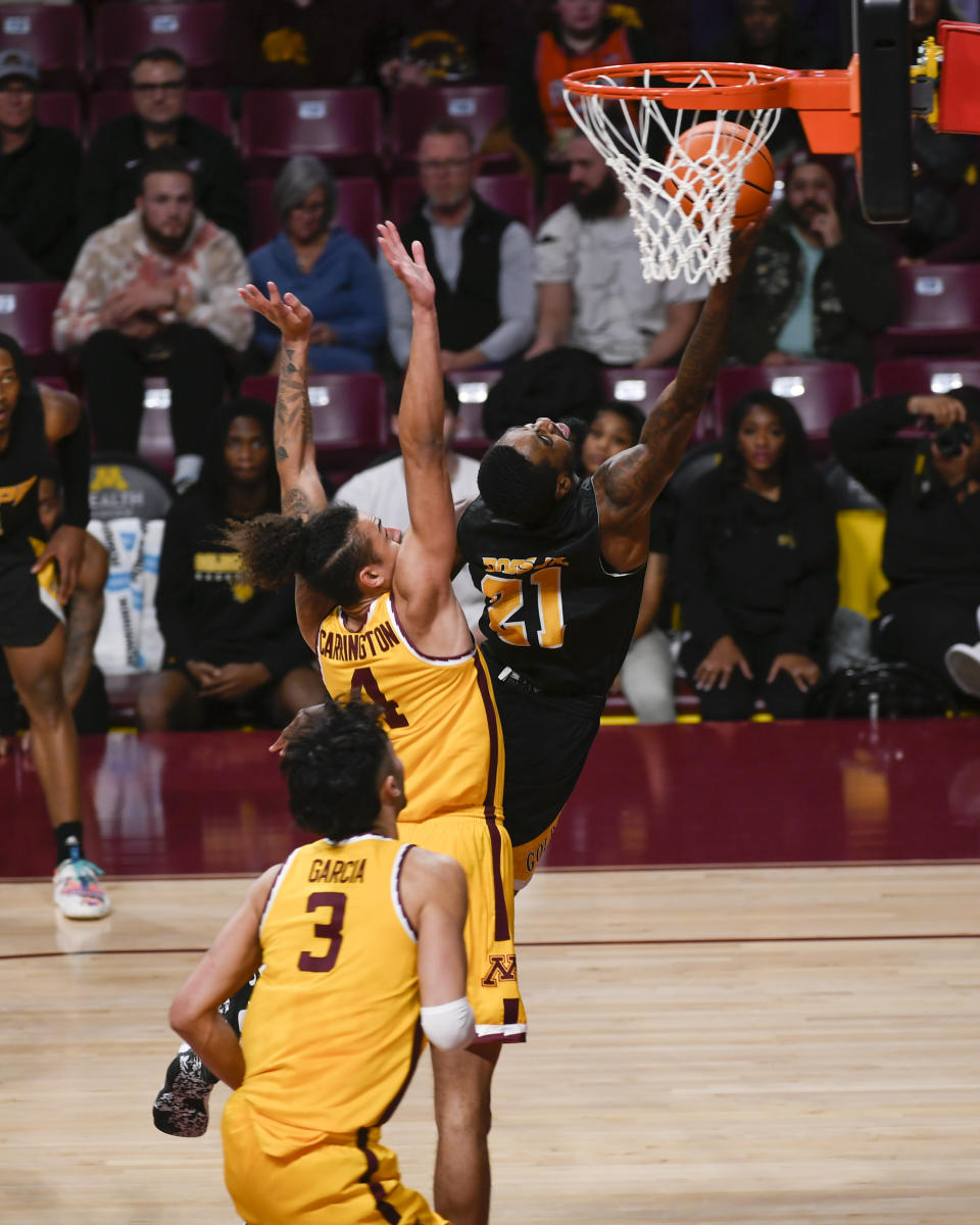 Arkansas-Pine Bluff guard Shaun Doss Jr. (21) drives past Minnesota guard Braeden Carrington (4) to score during the second half of an NCAA college basketball game on Wednesday, Dec. 14, 2022, in Minneapolis. Minnesota won 72-56.(AP Photo/Craig Lassig)