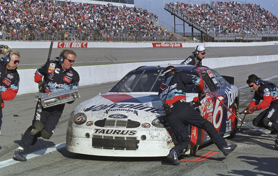 FILE - Crew members work on the car of driver Mark Martin during his last pit stop in the NASCAR Cup Series auto race at North Carolina Motor Speedway near Rockingham, N.C., Feb. 21, 1999. When NASCAR last raced at Rockingham, it was owned by International Speedway Corporation. At that point the one-mile track had already lost one of its race dates on the Cup Series schedule and was sold to Speedway Motorsports Incorporated. SMI moved the Rockingham's remaining date to Texas Motor Speedway, and shuttered the track. (AP Photo/Alan Marler, File)