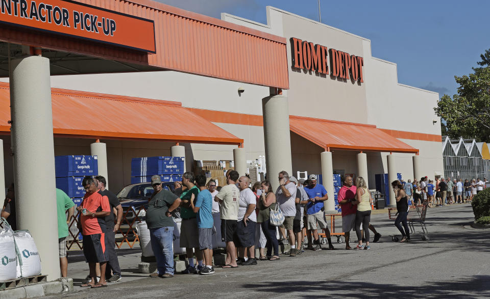 FILE - In this Wednesday, Sept. 12, 2018 file photo, people line up outside a Home Depot for a new supply of generators and plywood in advance of Hurricane Florence in Wilmington, N.C. "It's a year-round thing for us," said Margaret Smith, spokeswoman for Atlanta-based Home Depot. "When it's hurricane season, we are operating 24 hours a day." (AP Photo/Chuck Burton, File)