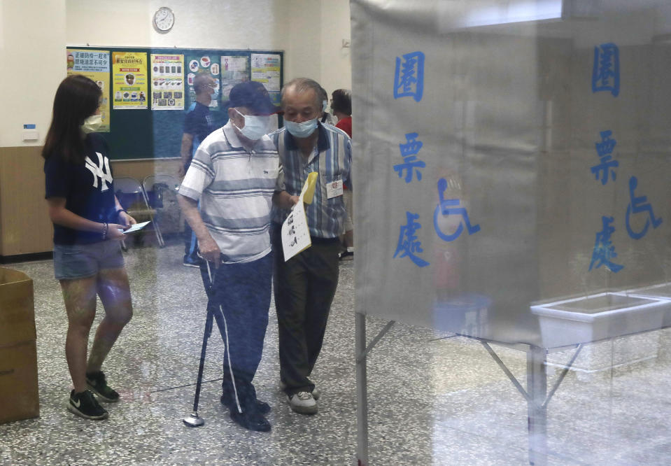 Members of the Nationalist Party, or KMT, prepare to cast their ballot for election of its party chairman at a polling station in Taipei, Taiwan, Saturday, Sept. 25, 2021. Fraught relations with neighboring China are dominating Saturday's election for the leader of Taiwan’s main opposition Nationalist Party. (AP Photo/Chiang Ying-ying)