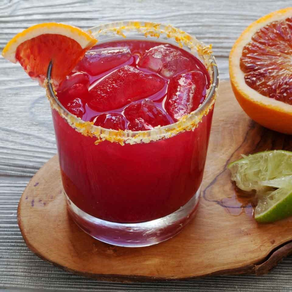 red colored drink in a glass with blood orange slice garnish