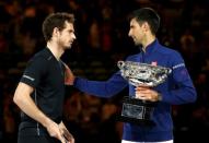 Serbia's Novak Djokovic (R) consoles Britain's Andy Murray while holding the men's singles trophy after winning their final match at the Australian Open tennis tournament at Melbourne Park, Australia, January 31, 2016. REUTERS/Issei Kato