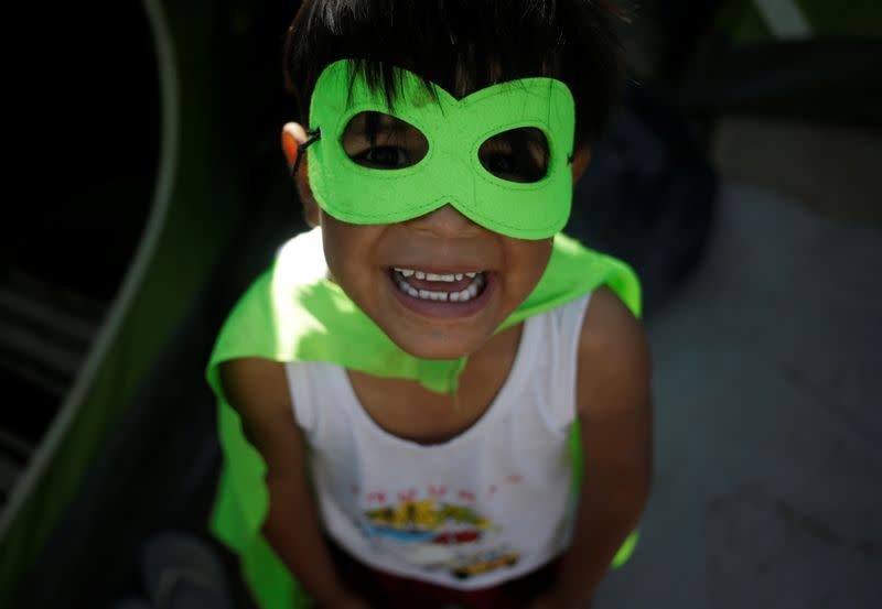 A migrant boy, asylum seeker sent back to Mexico from the U.S. under the Remain in Mexico program officially named Migrant Protection Protocols (MPP), poses for a picture with a mask at provisional campsite near the Rio Bravo in Matamoros