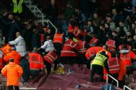 Stewards intervene as the home and away fans confront each other during the match between West Ham and Manchester City at Upton Park