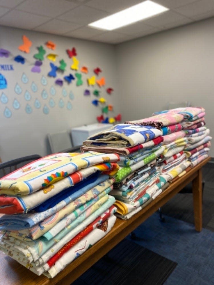 Stacks of handmade baby blankets from the New Washington Community Quilters.