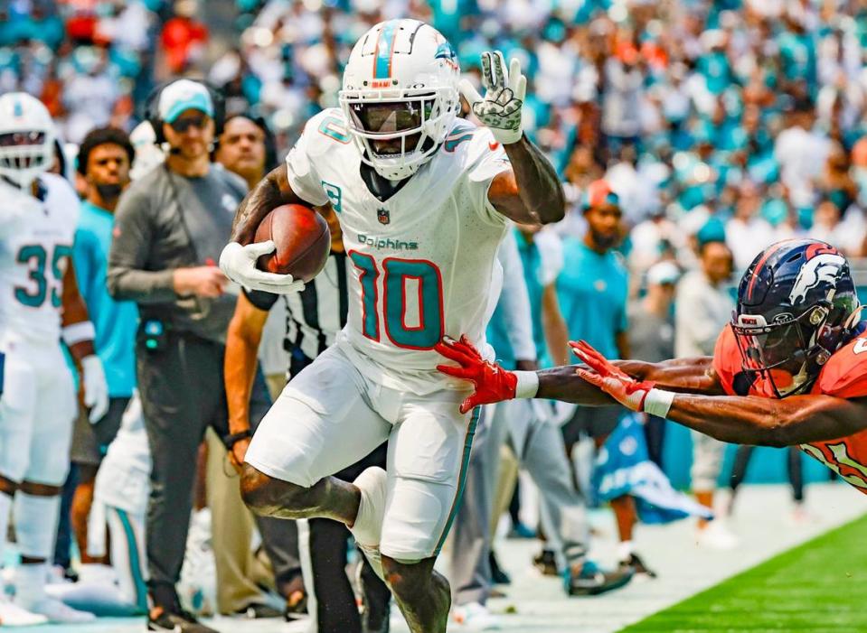 Miami Dolphins wide receiver Tyreek Hill (10) carries the ball as Denver Broncos cornerback Essang Bassey (21) defends in the first quarter at Hard Rock Stadium in Miami Gardens on Sunday, September 24, 2023.
