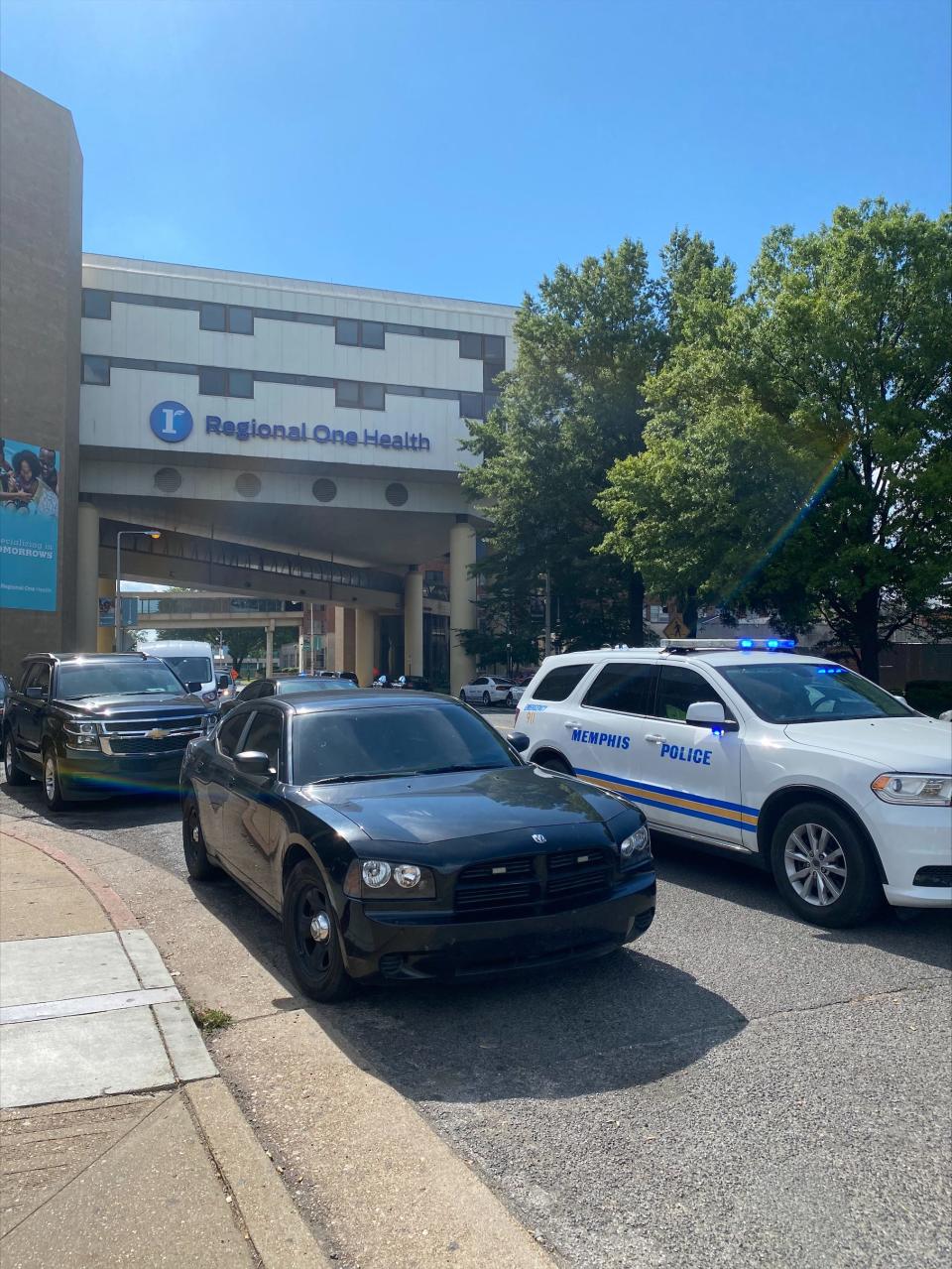 Dozens of marked and unmarked vehicles, as well as a handful of Memphis police officers, wait outside of Regional One Health. 
A Memphis police officer was shot by a suspect Saturday, and rushed to the hospital's