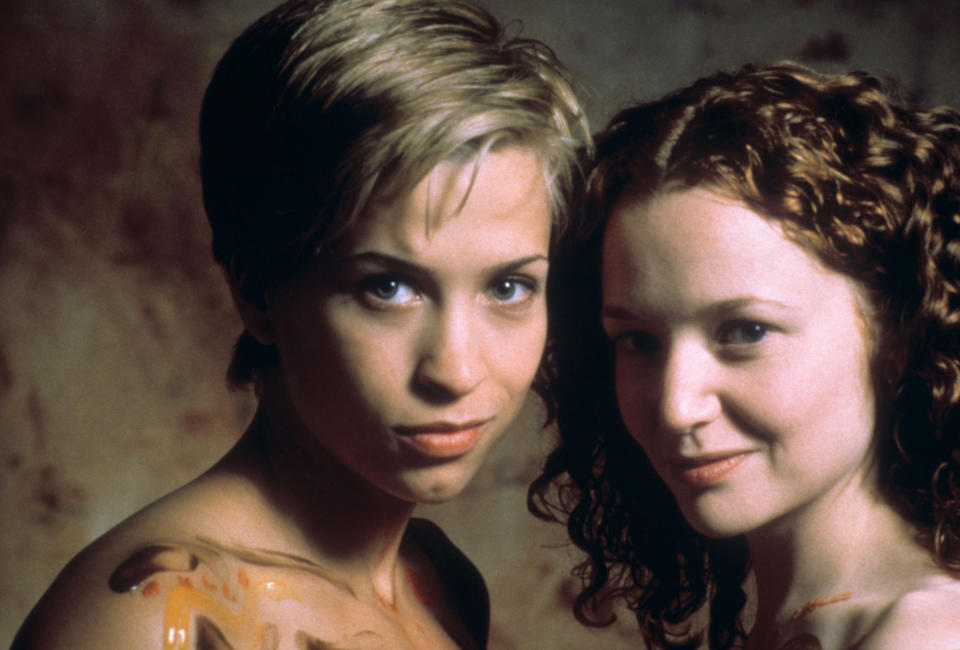 Unknown women pose closely for a photo, one with short hair and the other with curly hair