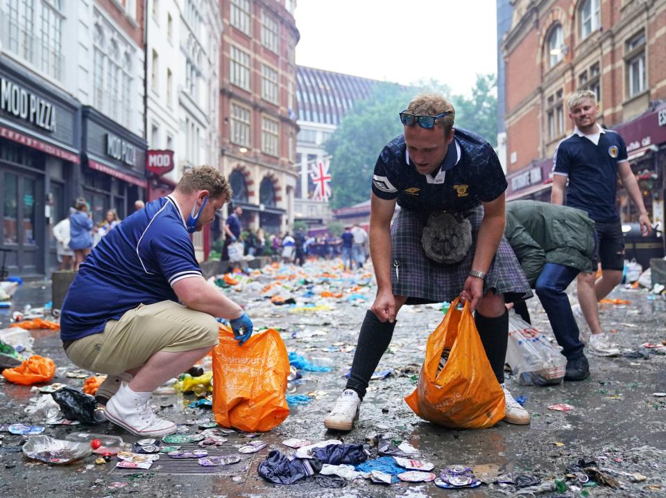 Scotland fans clean up litter in Irving Street  near Leicester Square, London. (PA)