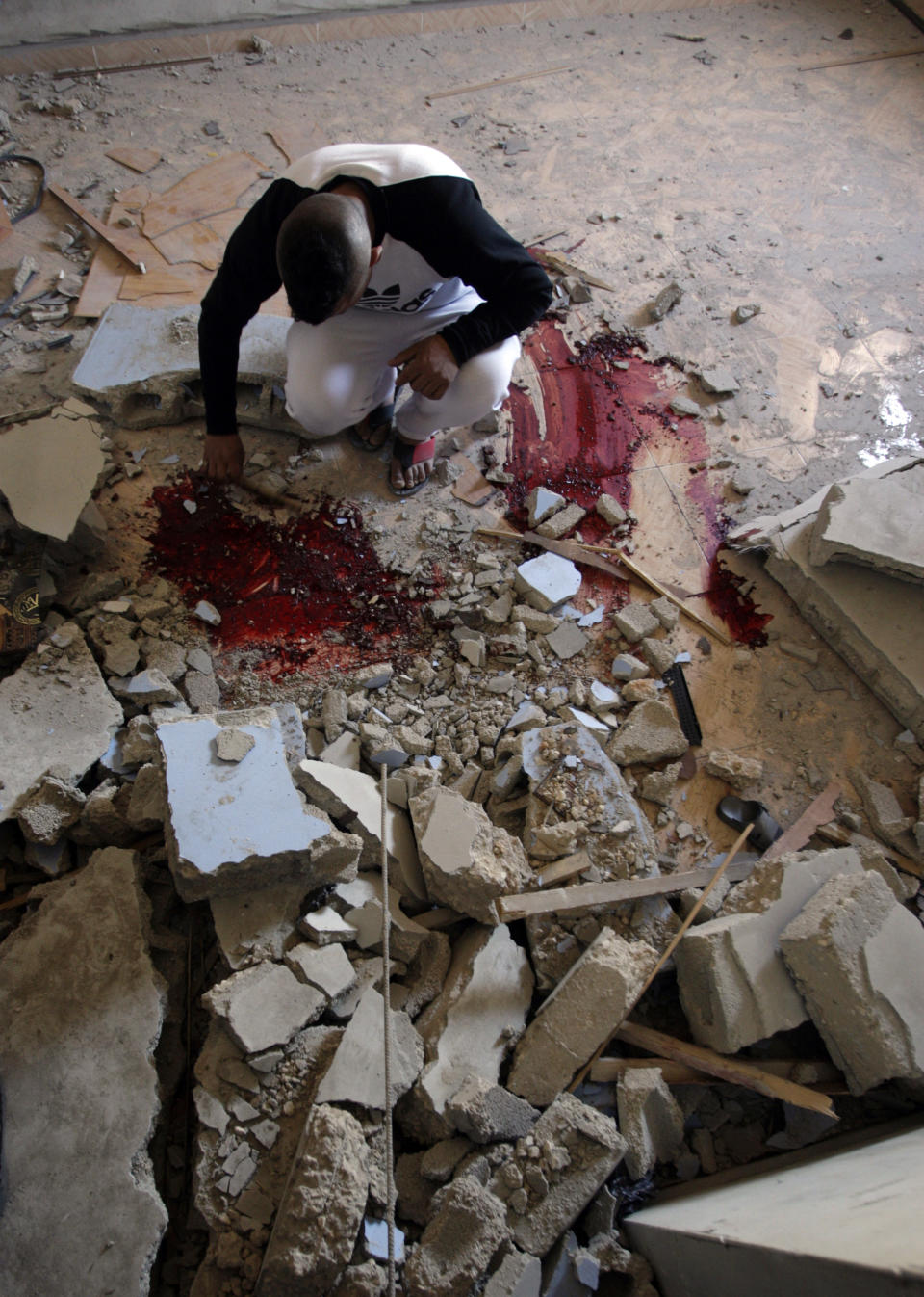 A Palestinian inspects the blood-marked floor inside the home of Hamza Abu el-Heija, where he was killed by Israeli troops, in the West Bank refugee camp of Jenin, Saturday, March 22, 2014. Israeli troops killed at least four Palestinians in an early morning raid that was followed by a clash with angry protesters in a West Bank town on Saturday, the Israeli military and Palestinian security officials said, in the deadliest incident in months. The Israeli military said the raid aimed to arrest Hamza Abu el-Heija, a 22-year-old Hamas operative wanted for involvement in shooting and bombing attacks against Israelis. (AP Photo/Mohammed Ballas)