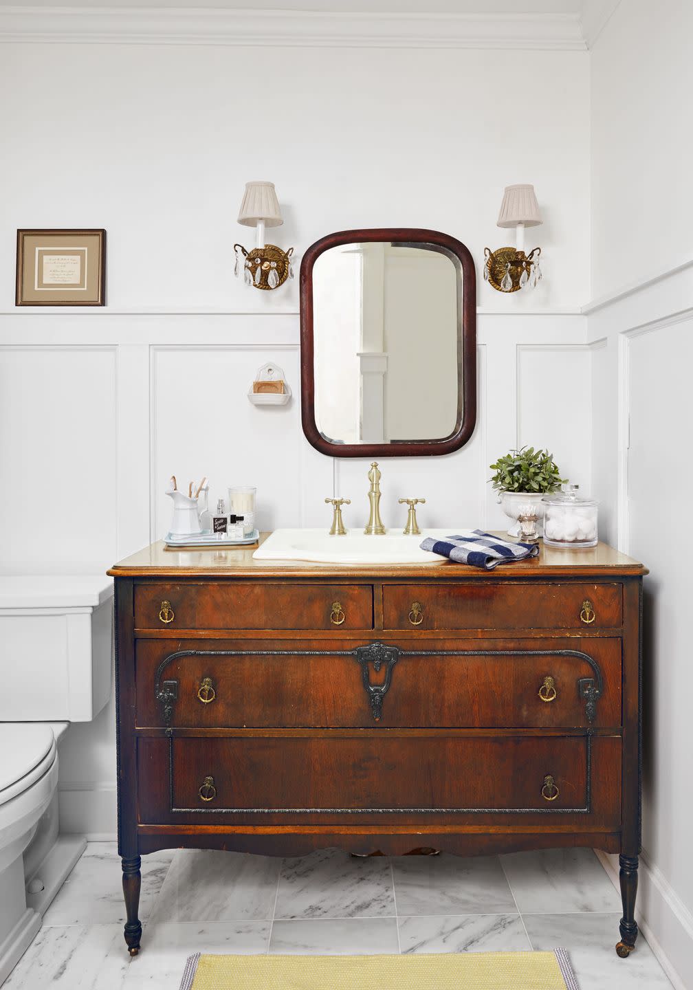classically appointed bathroom with wooden vanity and marble floor