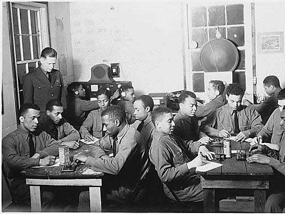 A black and white photo of a group of Black men at radio code practice.