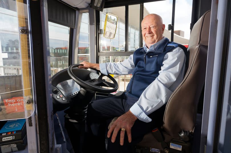 Kenny Beckers sits in his driver's seat and smiles for the camera