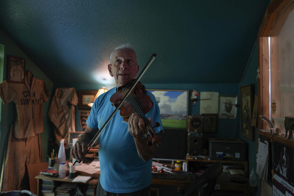 Mike Dulak plays the violin in his mandolin workshop in Rocheport, Mo., Friday, Sept. 8, 2023. Dulak does not associate with any religious group and self-identifies as "nothing in particular" when asked about his beliefs. He is part of the largest group of nonbelievers in the United States today, as nearly one in six adults claim the label "nothing in particular" according to the Associated Press- NORC Center for Public Affairs Research. (AP Photo/Jessie Wardarski)