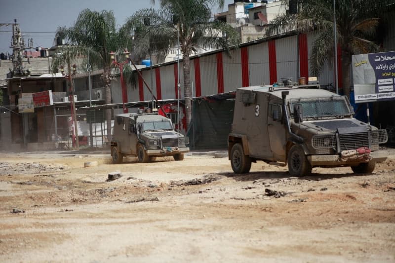 An Israeli armored military vehicle and a heavy machinery move on the road as operations carried out by Israeli forces against Nur Shams Refugee Camp two days ago continue in Tulkarm. Mohammed Nasser/APA Images via ZUMA Press Wire/dpa