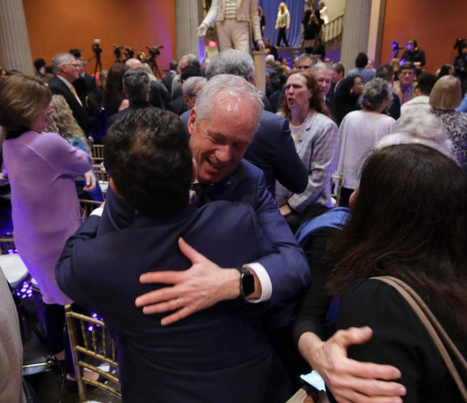 Mayor Craig Greenberg gets a hug from former mayor Greg Fischer at Metro Hall on Monday, January 2, 2023