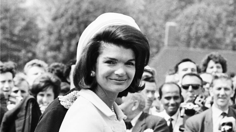 Jacqueline Kennedy (1929 - 1994) attends the inauguration of a memorial to her husband John F. Kennedy in Runnymede, Surrey, nearly eighteen months after his assassination. Holding her hand is her young son, John F. Kennedy Jr. (1960 - 1999)