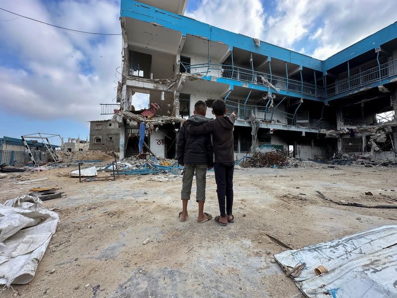 Palestinian children inspect their destroyed school in the southern Gaza Strip