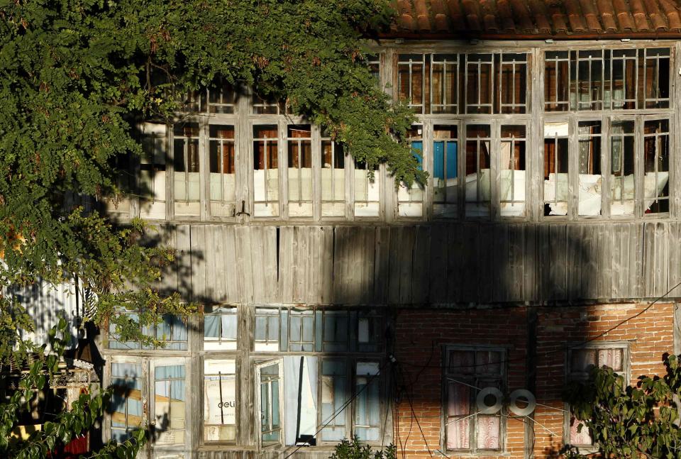 A cable car casts a shadow on a residential building in the town of Chiatura