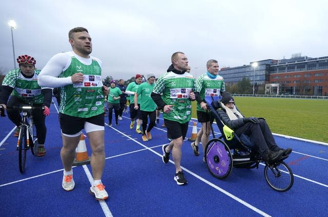 Ian Madigan (left), Keith Earls (centre) and Gordon D’arcy push Charlie Bird during the extra mile leg (Niall Carson/PA)