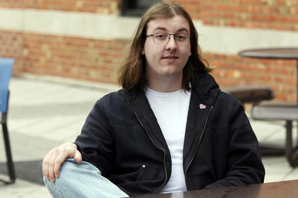 University of Kansas junior Chris Raithel pauses while speaking with fellow students outside the university's Memorial Union, Tuesday, March 26, 2024, in Lawrence, Kan. Raithel, who is non-binary, spent months drafting a proposal approved by the university's Student Senate, asking administrators to add pro-transgender rights language to the school's student rights code. (AP Photo/John Hanna)