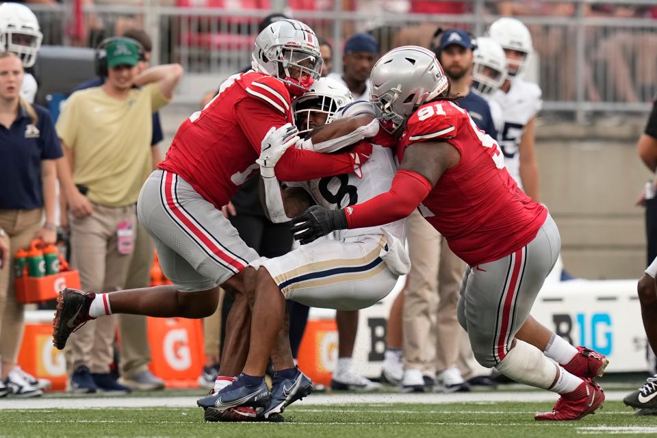 Aug 31, 2024; Columbus, OH, USA; Ohio State Buckeyes linebacker C.J. Hicks (11) and defensive tackle Tyleik Williams (91) tackle Akron Zips running back Jordon Simmons (8) during the second half of the NCAA football game at Ohio Stadium. Ohio State won 52-6.