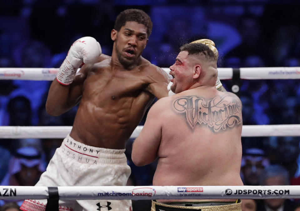 Defending champion Andy Ruiz Jr. takes a punch to the face during his fight against Britain's Anthony Joshua, right, in their World Heavyweight Championship contest at the Diriyah Arena, Riyadh, Saudi Arabia early Sunday Dec. 8, 2019. (AP Photo/Hassan Ammar)