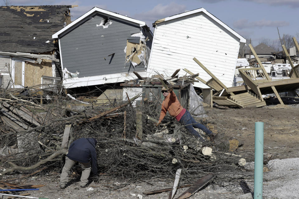 Men sort construction debris from tree limbs Friday, March 6, 2020, in Nashville, Tenn. Residents and businesses face a huge cleanup effort after tornadoes hit the state Tuesday. (AP Photo/Mark Humphrey)