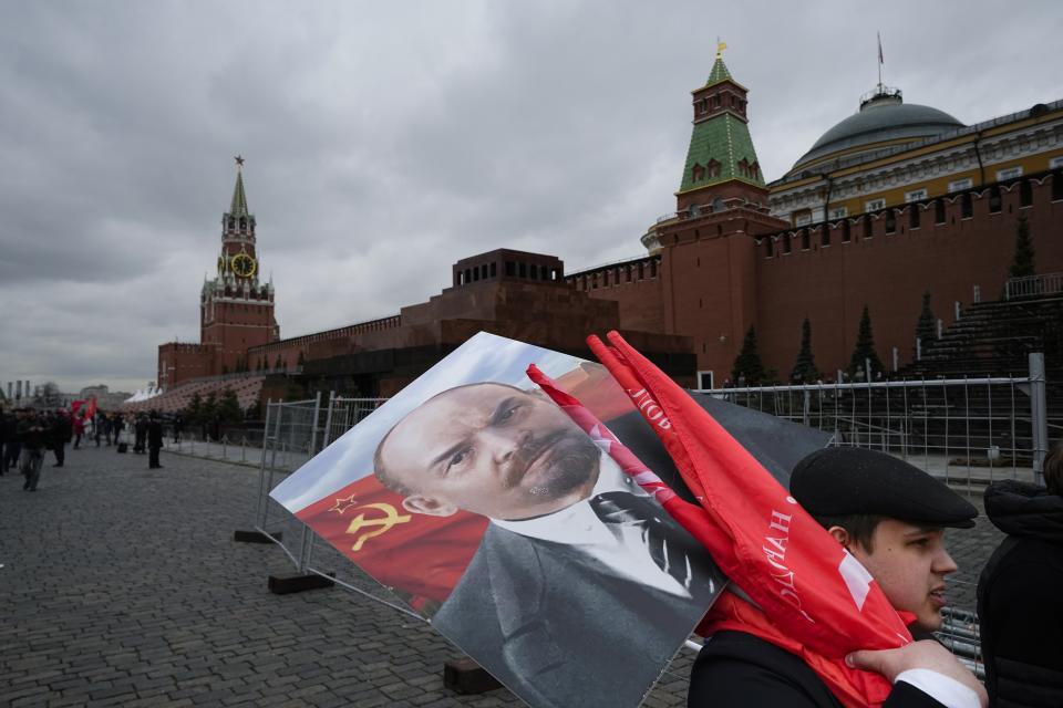 FILE - Russian Communists carry a portrait of Vladimir Lenin, the founder of the Soviet Union, and red flags after visiting his mausoleum marking the 152nd anniversary of his birth in Red Square in Moscow, Russia, on Friday, April 22, 2022. While still lauded by Communists, Lenin is an afterthought in modern Russia. (AP Photo/Alexander Zemlianichenko, File)