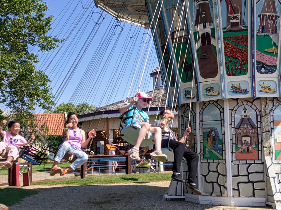 Families enjoy the swing ride Sunday, July 25, at Nelis' Dutch Village in Holland Township.