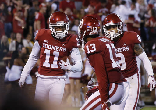 Oklahoma’s Parnell Motley (L) celebrates with teammates Tre Norwood (C) and Kahlil Haughton (R) after intercepting a pass in overtime to end an NCAA college football game against Army in Norman, Okla., Saturday, Sept. 22, 2018. (AP Photo)