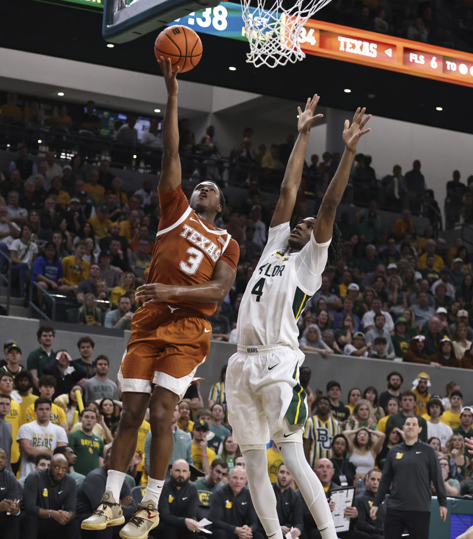 Texas guard Max Abmas, left, scores over Baylor guard Ja'Kobe Walter in the first half of an NCAA college basketball game, Monday, March 4, 2024, in Waco, Texas. (Rod Aydelotte/Waco Tribune-Herald via AP)